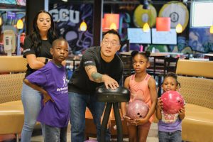 Big for a Day credit union volunteers and waiting littles bowling